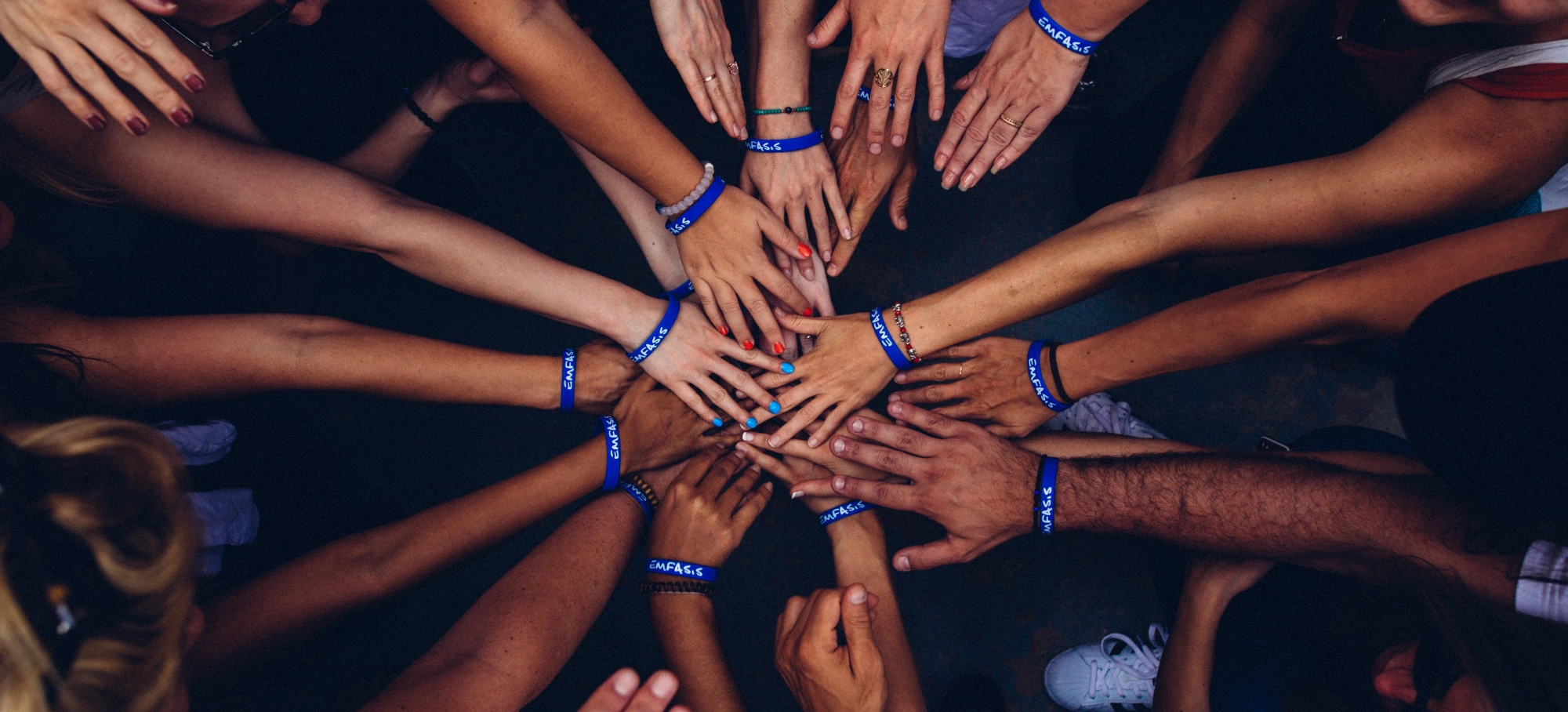 Many people putting their hands together to show the power of community for this fundraiser